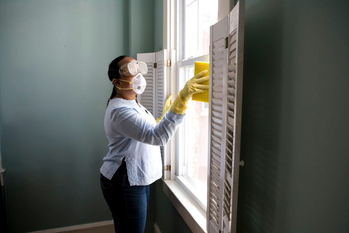 Happy Tide cleaner carefully wiping down window shutters