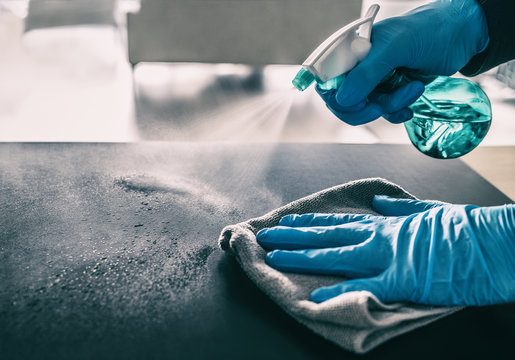 Close-up of a gloved hand wiping a countertop clean